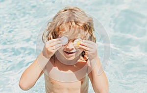 Happy child having fun at swimming pool on summer day. Children playing in blue sea water. Tropical summer vacation