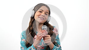 happy child in headphones talk to camera interviewing and giving microphone to respondent, interview