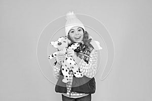 Happy child hold soft toy. Little girl smile with toy dog. Dreaming about real dog. Kids toy shop or store. Winter style