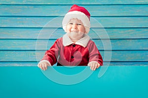 Happy child holding blue Christmas banner blank against wooden background