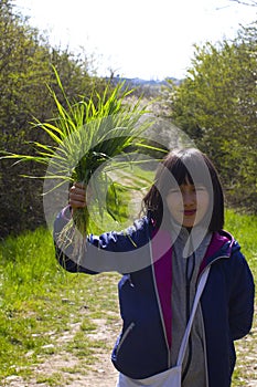 Happy child holding a bunch of springtime grass for life