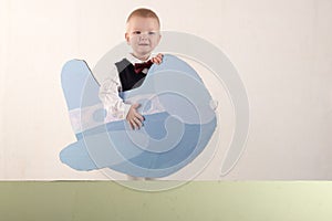 A happy child is holding a Santa Claus mask and an empty banner. Greeting card with Christmas. The concept of Christmas holidays