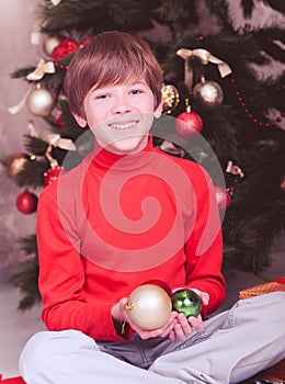 Happy child holding christmas decorations in room