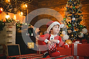 Happy child holding a red gift box with both hands. The morning before Christmas. Christmas Celebration holiday. New