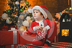 Happy child holding a red gift box with both hands. The morning before Christmas. Christmas Celebration holiday. New