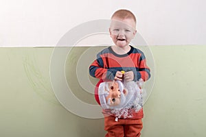 A happy child is holding a Santa Claus mask and an empty banner. Greeting card with Christmas. The concept of Christmas holidays