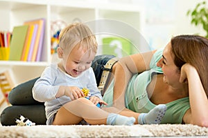 Happy child holds animal toy playing with mom in