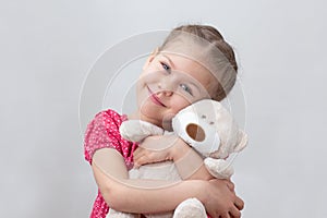 Happy child hugging teddy bear