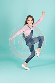 Happy child in jeans overall dance, fashion