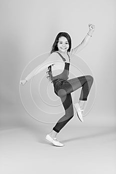 Happy child in jeans overall dance, fashion