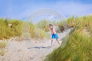 Happy child jumping in the dunes