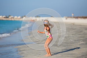 Happy child jumping in summer vacation on exotic tropical beach.