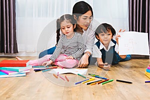 Happy child kid boy and girl son kindergarten drawing on peper teacher education with beautiful mother