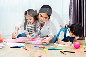 Happy child kid boy and girl son kindergarten drawing on peper teacher education with beautiful mother