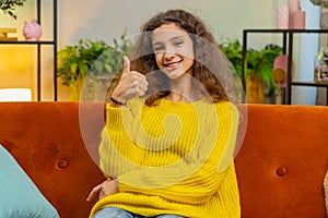 Happy child kid girl looking approvingly at camera showing thumbs up, like positive sign, good news