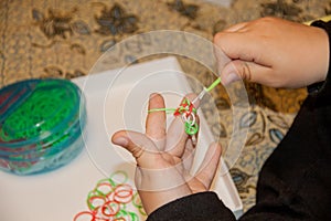 Happy child knits an elastic band.Kids hands