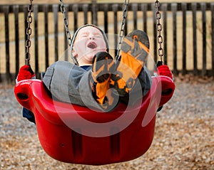 Happy child laughing while swinging