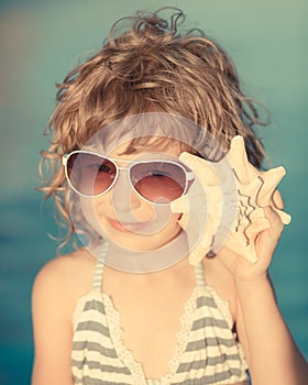 Happy child listen to seashell at the beach