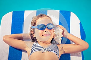 Happy child listen to seashell at the beach