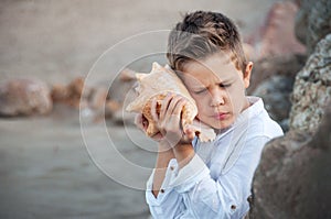 Happy child listen to seashell. vacations concept.