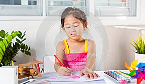 Happy child little girl colorful drawing pink heart on white paper