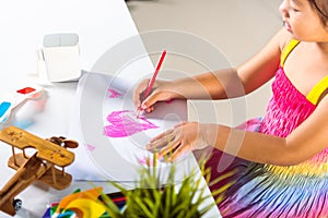 Happy child little girl colorful drawing pink heart on white paper