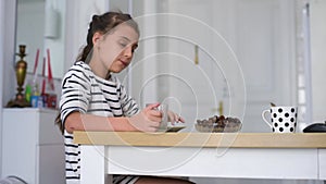 Happy child little girl eat date fruit in the summer home kitchen.