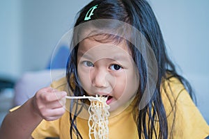 Happy Child or Little girl eating delicious noodle, kid have fun and joyful with eating