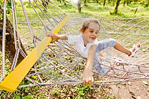 Happy Child Lying in Hammock. Cute Smiling Little Girl rides in Hammock in Nature. Pleasant summer leisure