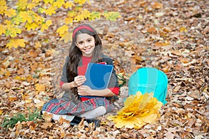 happy child with maple leaf bunch and backpack outdoor. autumn nature. childhood happiness.