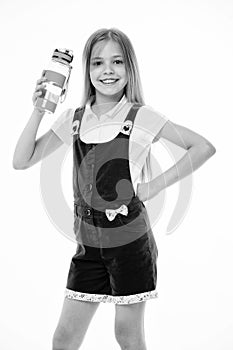 Happy child in pink jumpsuit hold water bottle. Little girl smile with plastic bottle isolated on white. Drinking water