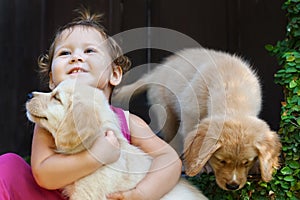 Happy child play and hug family pet - labrador puppy