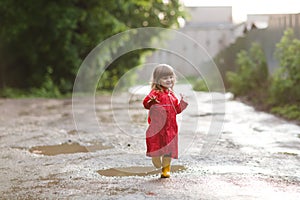 Happy child playing also runs on pools after a rain