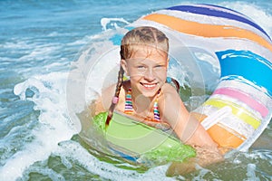 Happy child playing in blue water of ocean on a tropical resort