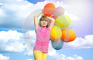 Happy child playing with colorful toy balloons outdoors