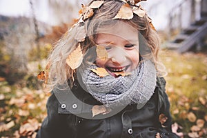 Happy child playing with leaves in autumn. Seasonal outdoor activities with kids