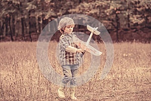 Happy child playing outdoors. Happy boy play airplane. Little boy with plane