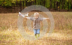 Happy child playing outdoors. Happy boy play airplane. Little boy with plane. Little kid dreams of being a pilot. Child