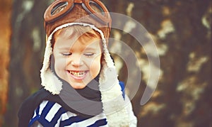 Happy child playing pilot aviator outdoors in autumn