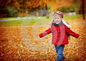Happy child playing pilot aviator outdoors in autumn