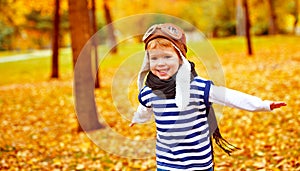 Happy child playing pilot aviator outdoors in autumn