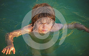 Happy child playing in the sea. Kid boy having fun on the beach. Summer vacation and healthy kids lifestyle concept.