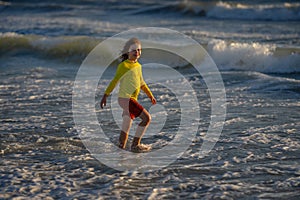 Happy child playing in the sea. Kid having fun outdoors. Summer vacation and healthy lifestyle concept. Cute kids having