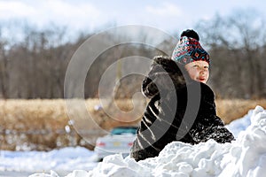 Happy child playing in snow on cold winter day