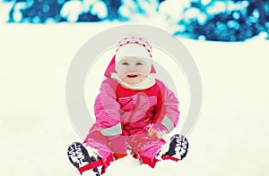Happy child playing on snow in winter day