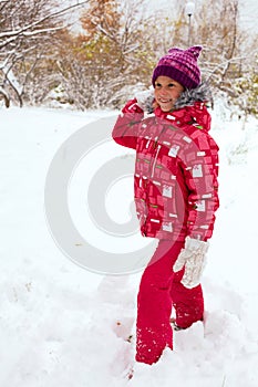 Happy child playing with snowballs in winter