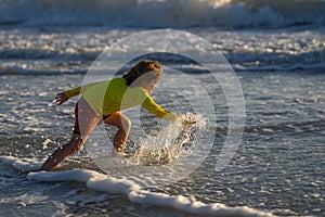 Happy child playing in splashing water on summer sea. Summer vacation. Kid play of waves at sea. little kid playing in