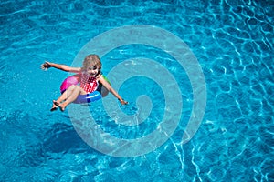 Happy child playing in swimming pool