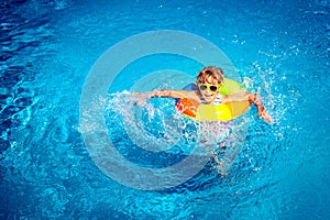 Happy child playing in swimming pool