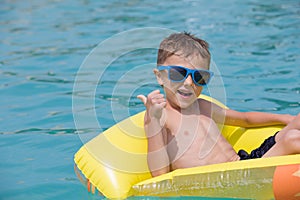 Happy child playing on the swimming pool at the day time.